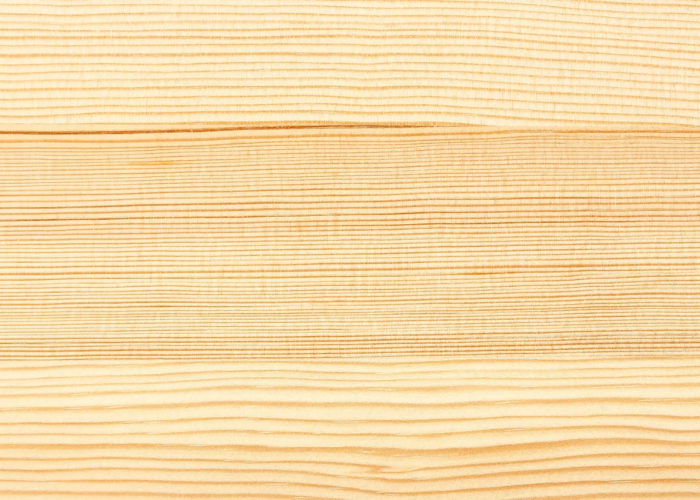 Light-colored pine wood texture with natural knots showing pale yellow tone for budget-friendly furniture